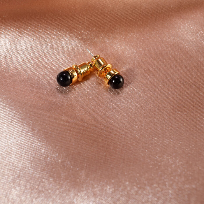 Close-up showing raw or polished black tourmaline set in gold posts