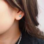 Model wearing the mini turquoise studs, highlighting subtle glow and size