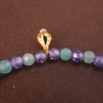 Close-up of aquamarine, amethyst, and pearl beads on adjustable bracelet