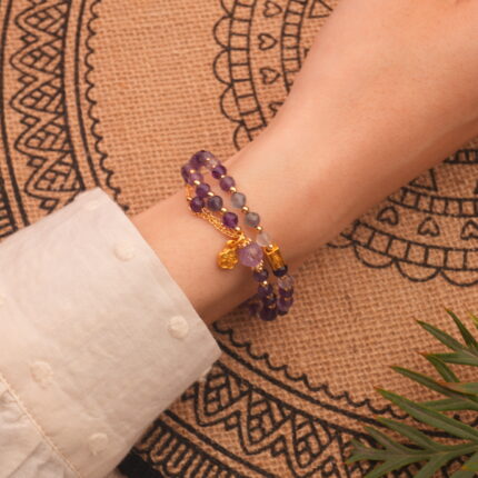 Close-up of amethyst double wrap bracelet worn on wrist showing adjustable fit and polished beads