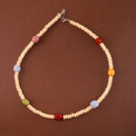 Handmade blue banded agate, red agate, and white chalcedony necklace on neutral background