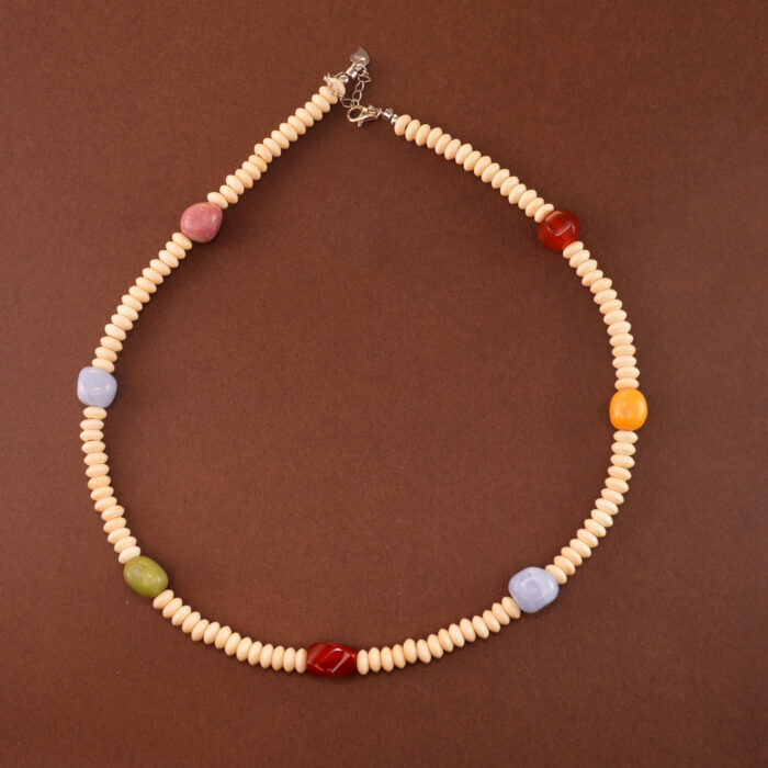Handmade blue banded agate, red agate, and white chalcedony necklace on neutral background