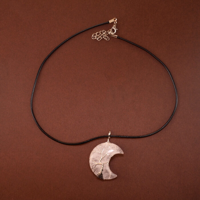Handmade moon pendant necklace with clear quartz crystal on white background