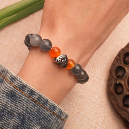 Bracelet worn on wrist, styled with a clean, minimalist outfit to highlight its protective, natural stone look.