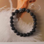 Bracelet displayed on natural stone and wood elements, evoking grounding energy.