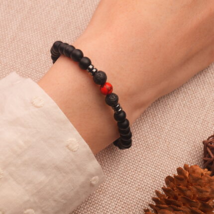 Men wearing matte black obsidian and red turquoise bracelet on wrist with casual outfit