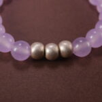 Close-up of polished lavender amethyst and moon charm detailing