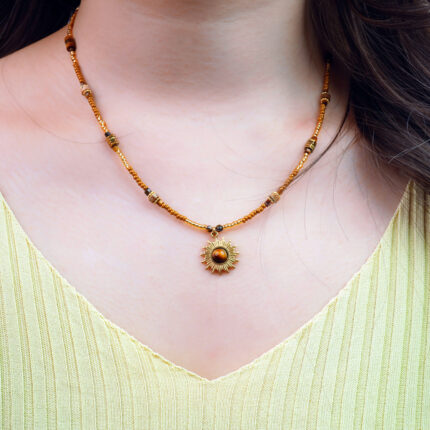 Model wearing tiger eye sunflower bead necklace, showing pendant on collarbone