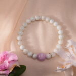 Kunzite and White Chalcedony bracelet resting in a peaceful natural setting