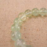 Close-up of heart-shaped Prehnite beads with soft green tones
