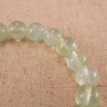 Close-up of heart-shaped Prehnite beads with soft green tones