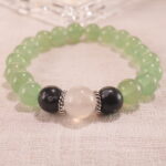 Close-up of 8mm beads: light green Prehnite, luminous Moonstone, and speckled Obsidian