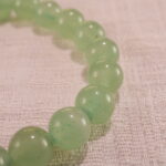 Close-up of 8mm beads: light green Prehnite, luminous Moonstone, and speckled Obsidian