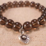 Detailed view of the S925 silver accents and polished smoky quartz stones on the beaded bracelet