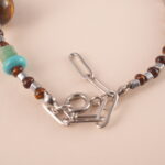 Adjustable tiger eye and turquoise gemstone bracelet with braided cord on white background