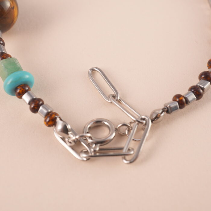 Adjustable tiger eye and turquoise gemstone bracelet with braided cord on white background