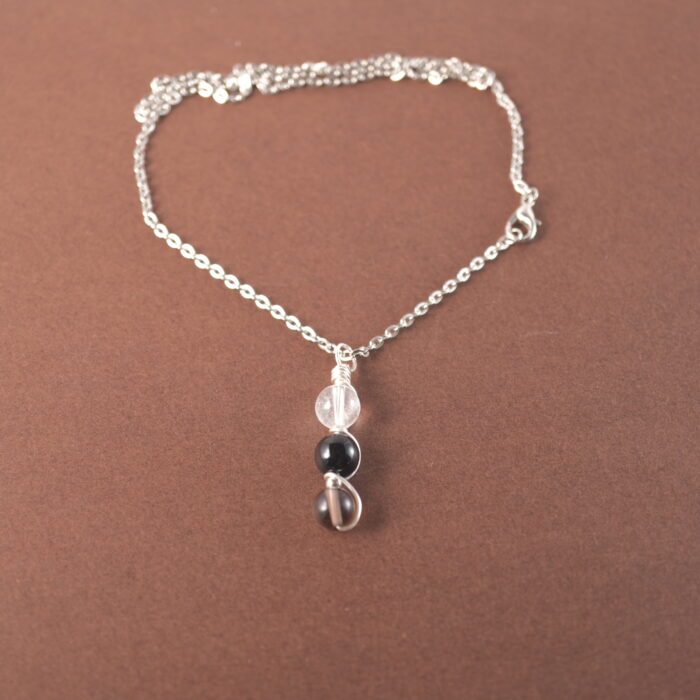 Capricorn zodiac necklace with clear quartz, obsidian, and smoky quartz gemstones.