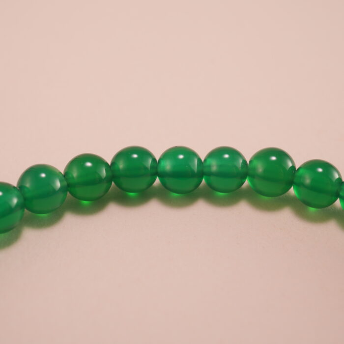 Close-up of green chalcedony bracelet with smooth finish.