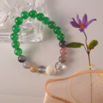 Close-up of lava stone and gemstone beaded bracelet showcasing green agate, banded agate, and clear quartz combination.