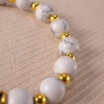 Close-up of howlite evil eye bracelet with matte white texture.