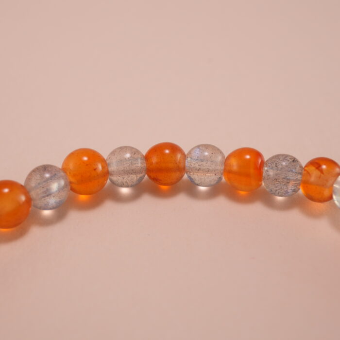 Close-up of orange chalcedony and gray moonstone bracelet with silver.