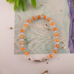 Bracelet in natural light showing warm orange and soft gray tones.