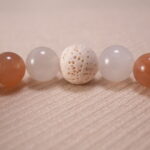 Close-up of peach moonstone bracelet with chalcedony and lava stone.