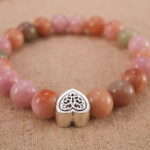 Close-up of pink Yanyuan agate bracelet with S925 silver charm.