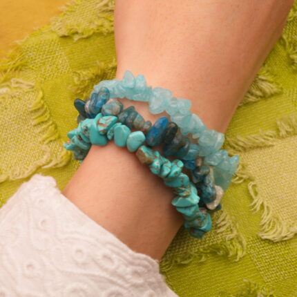 Model wearing stacked turquoise, apatite, and aquamarine.