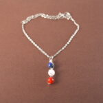 Taurus zodiac necklace with lapis lazuli, clear quartz, and red agate gemstones.
