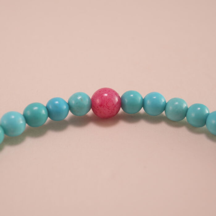 Close-up of turquoise and rhodochrosite bracelet with silver.