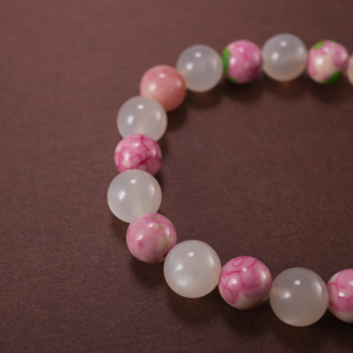Close-up of bracelet combining white chalcedony and rainbow fluorite beads.