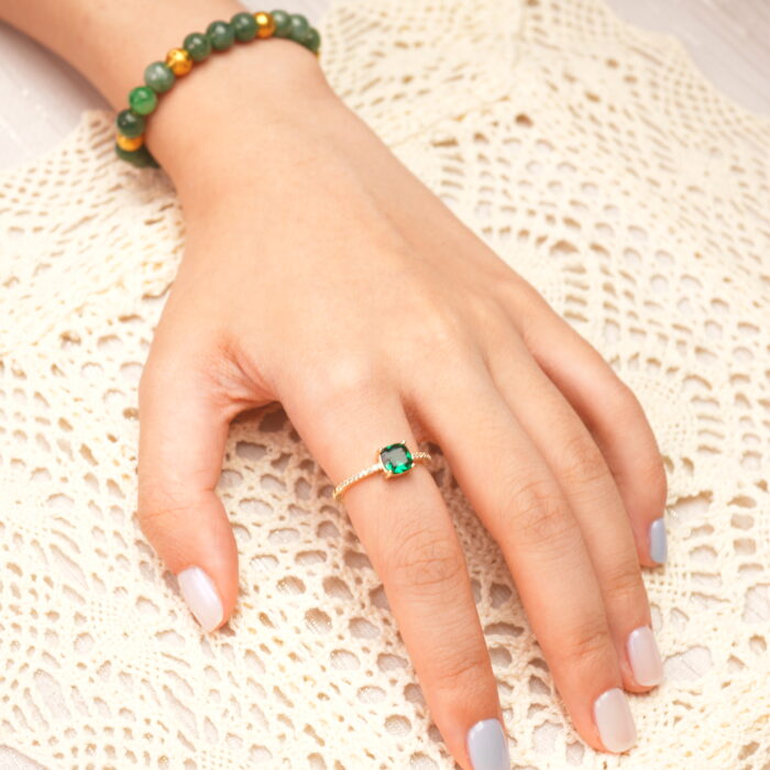 Emerald open ring shown on a hand, emphasizing its adjustable fit and vibrant gemstone glow.